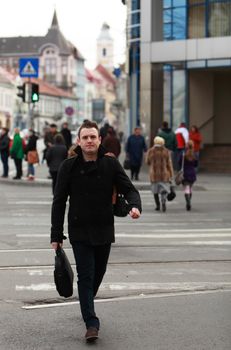 Businessman crossing the street in an old European city.