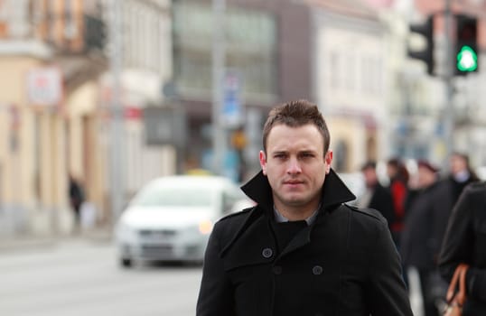 Environemental portrait of a young businessman in a street of an old European city.