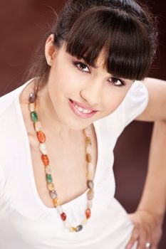 Pretty smiled woman white dressed with necklaces