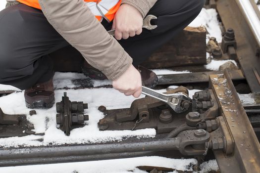 Man's hand with adjustable wrench at the railroad