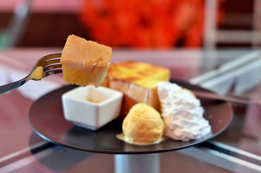 close up toast  on fork , toast and whipping cream with vanilla ice cream  served with honey sauce