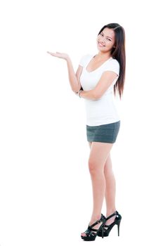 Portrait of a beautiful young Asian woman with hand outstretched presenting things over white background