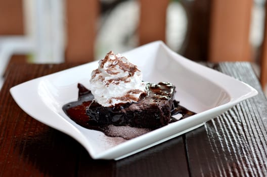 brownie cake served with chocolate sauce and whipped cream