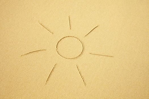 Simple sun drawn on sand of the beach