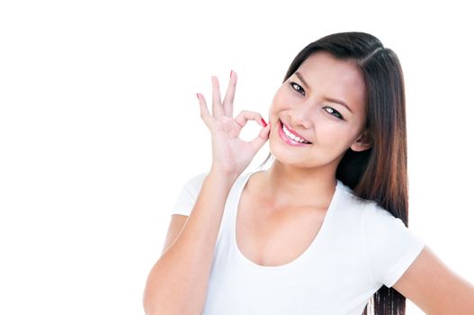 Portrait of an attractive young Asian woman showing OK gesture over white background