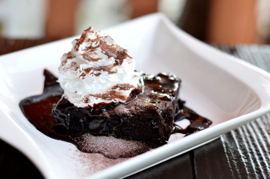 brownie cake served with chocolate sauce and whipped cream