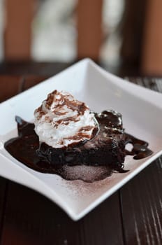 brownie cake served with chocolate sauce and whipped cream