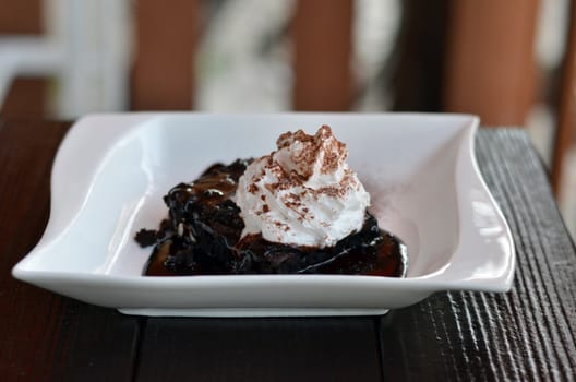 brownie cake served with chocolate sauce and whipped cream