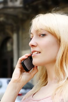 A young adult woman talking on the phone.