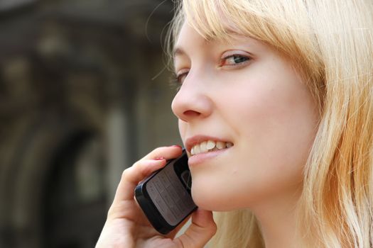 A young adult woman talking on the phone.