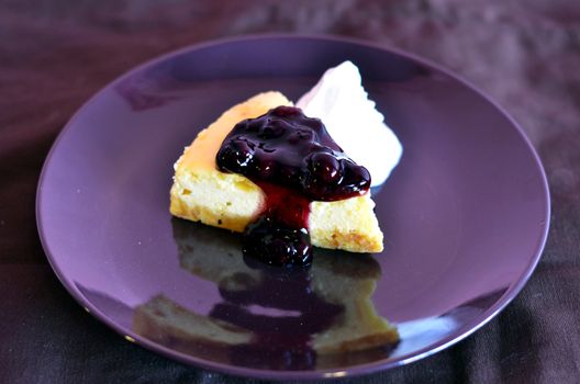 a slice of blueberry cheese cake served with whipped cream