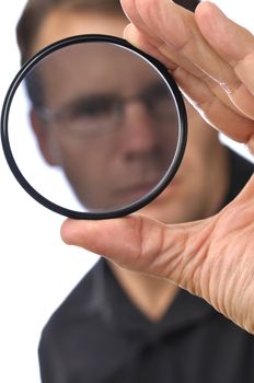 Closeup of photographer man holding and looking through circular polarizer filter 