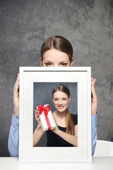 Girl holds a picture of a girl and a gift