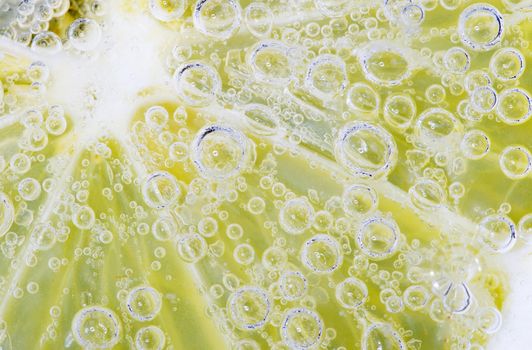 Close-up of a lemon slice with bubbles