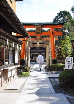 Zen priest against Fushimi Inari Taisha Shrine in Kyoto, Japan 