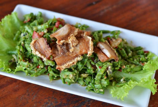 String bean spicy salad served with crispy pork