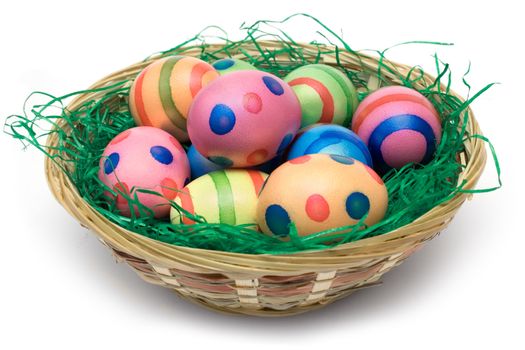 Bunch of colored eggs in a wooden basket. Isolated on a white background.