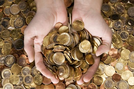 Female hands grabbing shiny coins.