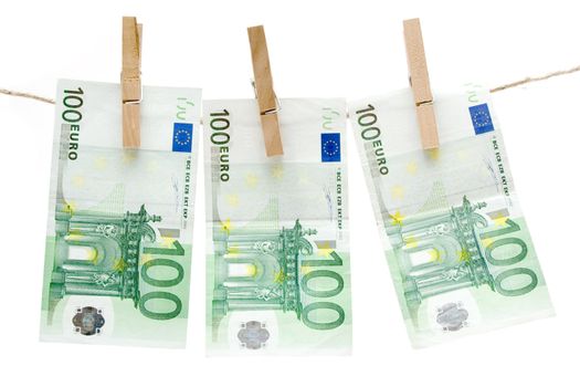 Three one hundred euro bills hanging on a clothesline. Isolated on a white background.