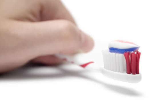 Hand holding a toothbrush. Isolated on white background. Shallow depth of field.