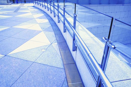 tiled floor, metallic handrails and glass fence fragments of modern urban square