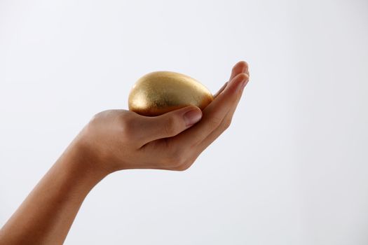 Hand holding a golden egg