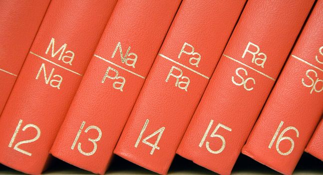 Row of red books in a bookshelf.