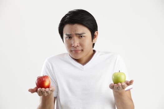 man holding an green apple and red apple