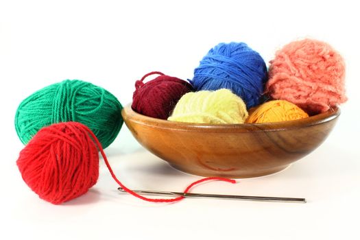 colorful balls of wool with crochet hook on a white background