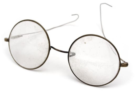 Old and grungy eyeglasses. Isolated on a white background.