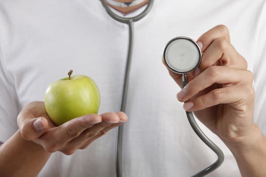 man holding a stethoscope and an apple