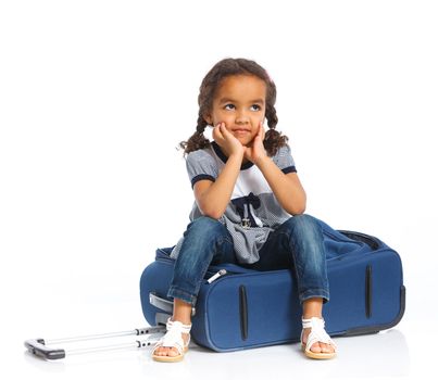 The young mulatto traveler girl with a suitcase. Isolated over white background