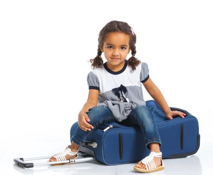 The young mulatto traveler girl with a suitcase. Isolated over white background