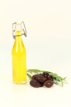 Olive oil with black olives and a fresh olive branch