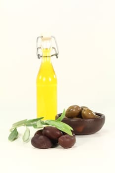 fresh Olive oil with black olives and a olive branch