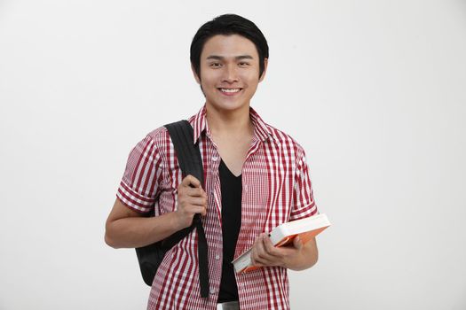 Young man standing and holding books