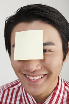 man with an adhesive note on his forehead