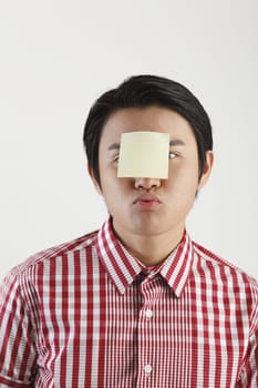 man with an adhesive note on his forehead