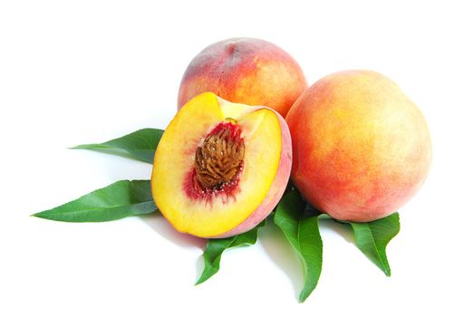 fresh peach fruits with green leaves isolated on white