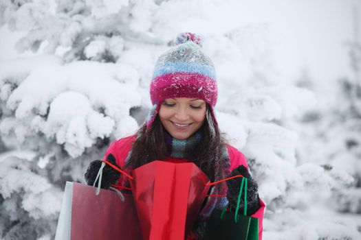 winter girl with gift bags on snow background