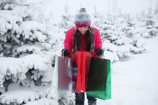 winter girl with gift bags on snow background