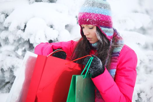 winter girl with gift bags on snow background