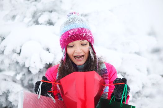 winter girl with gift bags on snow background