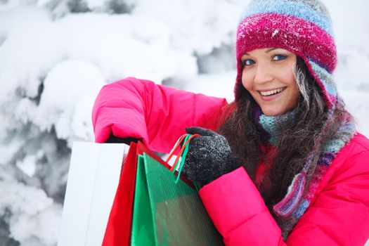 winter girl with gift bags on snow background