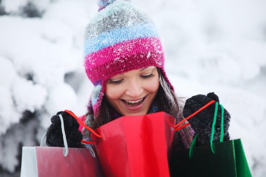 winter girl with gift bags on snow background