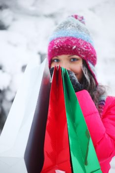 winter girl with gift bags on snow background