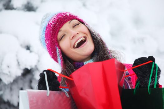 winter girl with gift bags on snow background