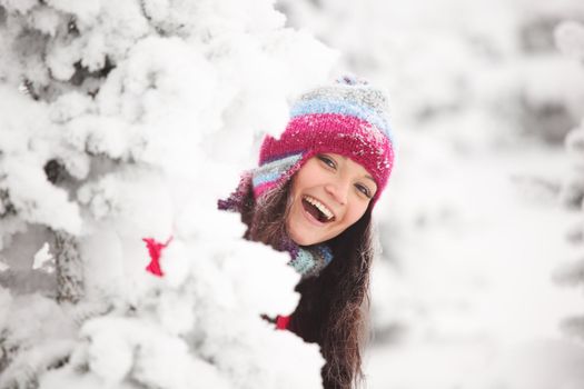 winter girl behind snow tree 