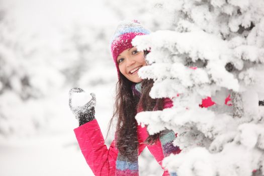 winter woman play snowballs on snow background