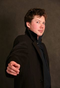 Young the man in a black coat in studio